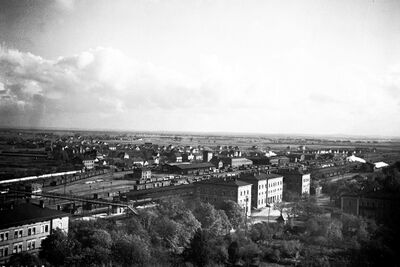 Das Foto zeigt das Gebäude des Hauptbahnhofs Ingolstadt vor der Zerstörung im Zweiten Weltkrieg 1945. Dahinter sind Gleise zu sehen.